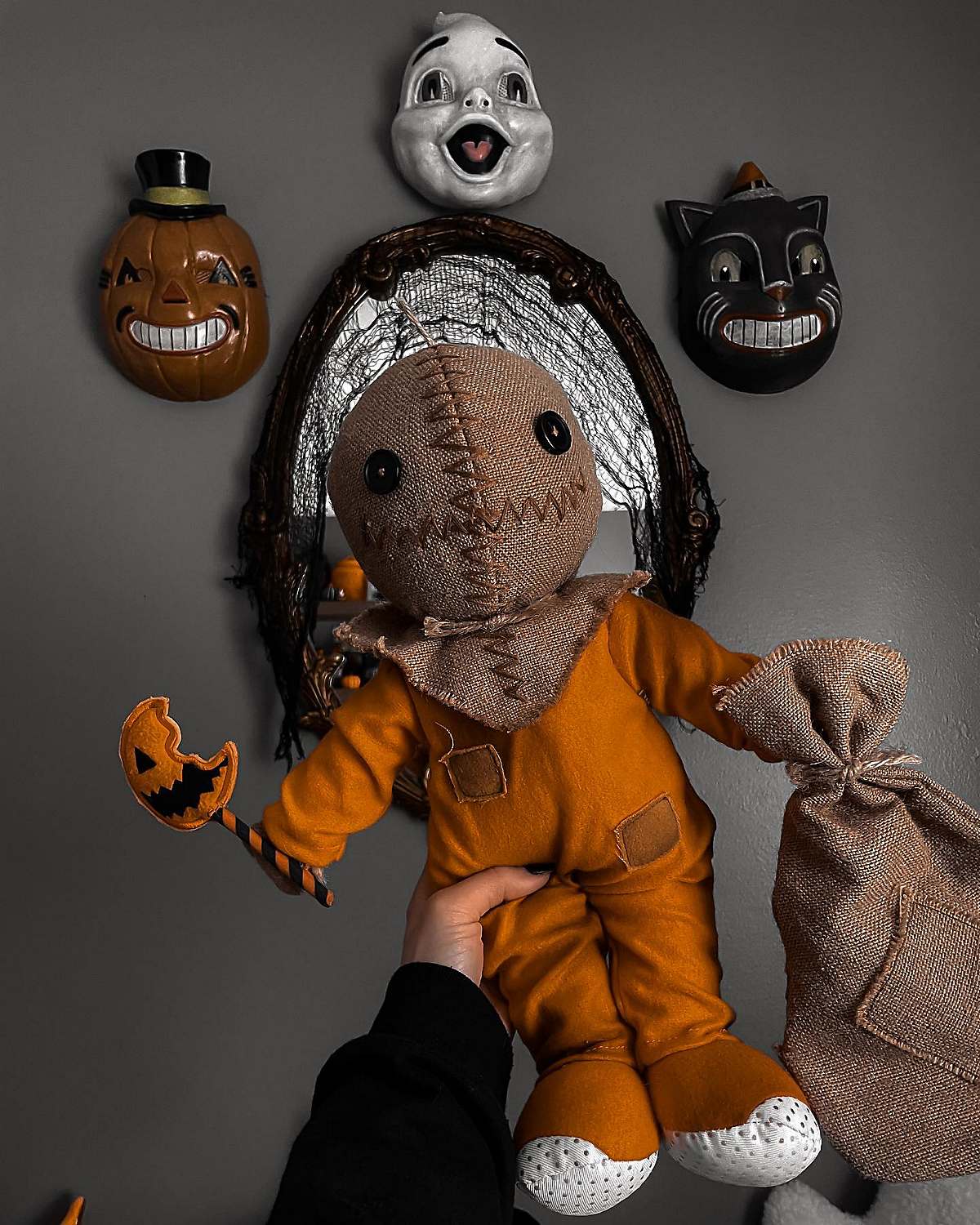 Sam Trick 'r Treat doll held up against wall featuring vintage Halloween masks