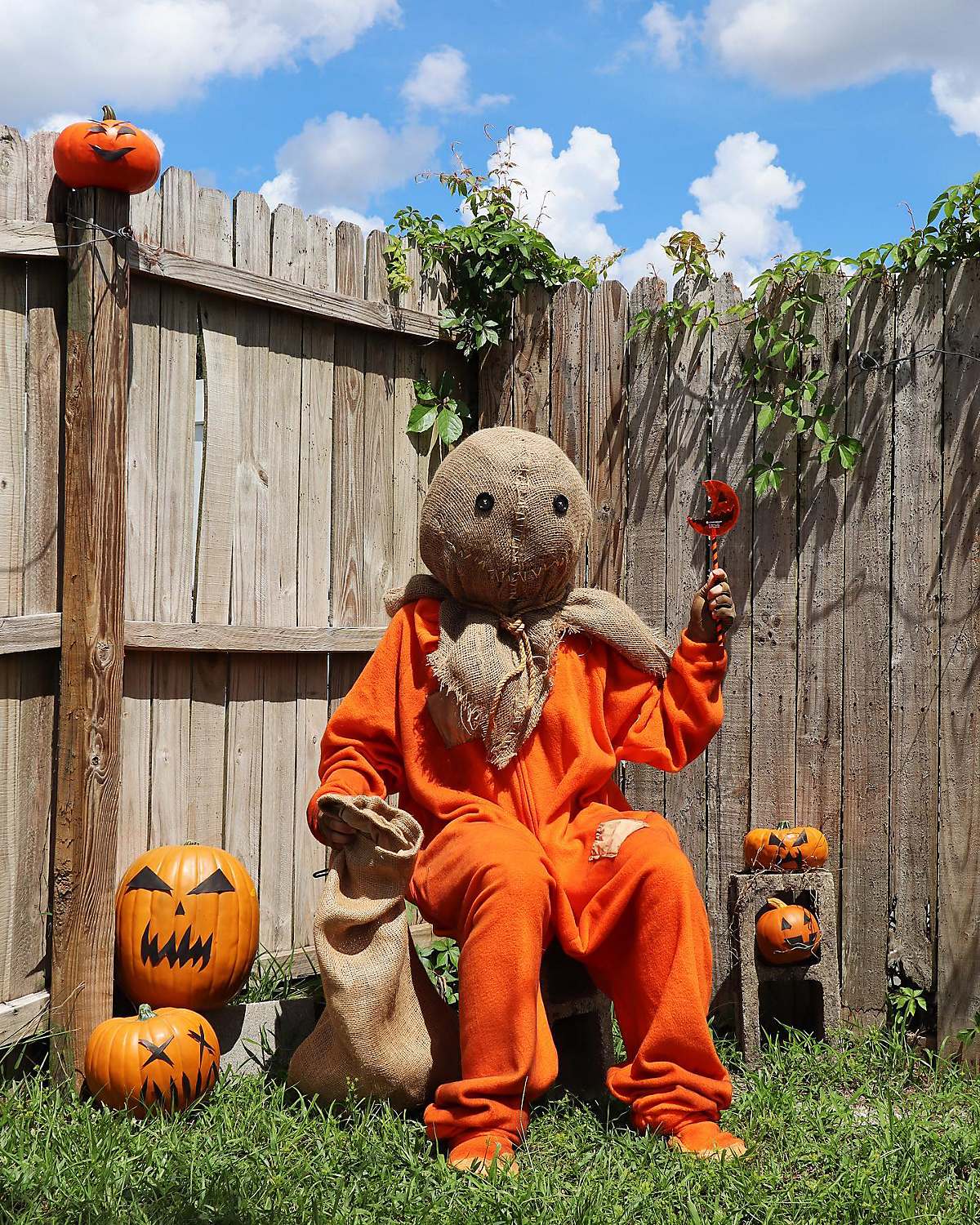 Person dressed as Sam from Trick 'r Treat holding lollipop and burlap sack